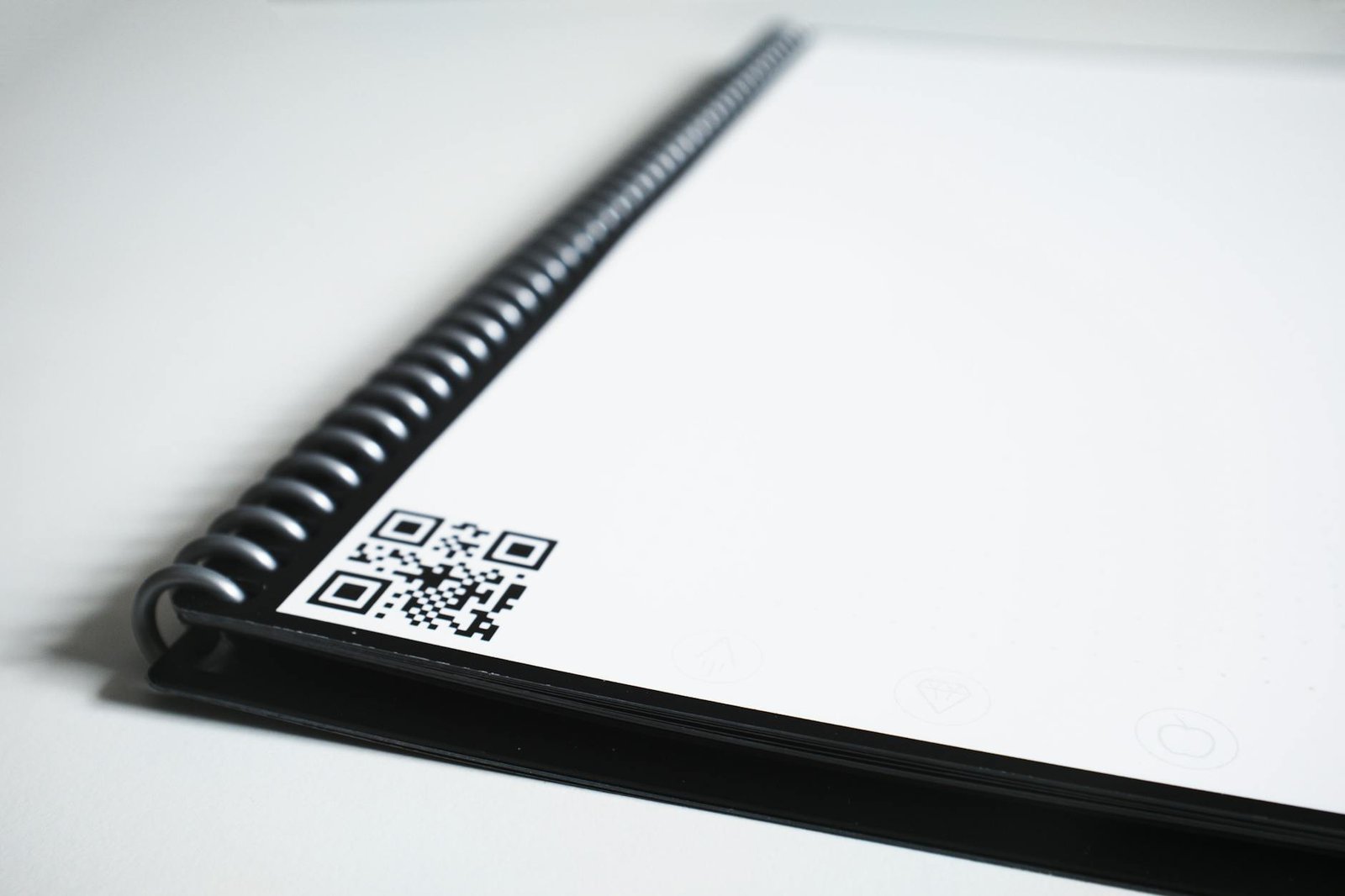 black spiral notebook with bar code on table